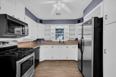 Kitchen featuring white cabinetry, light hardwood 