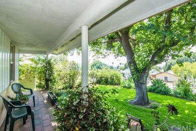 Covered front porch looking out to shaded lawn.