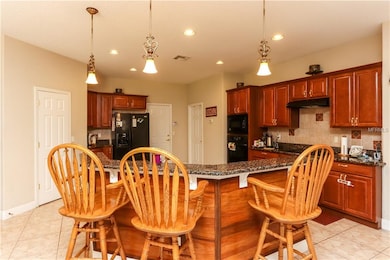 Kitchen features breakfast bar with granite counte