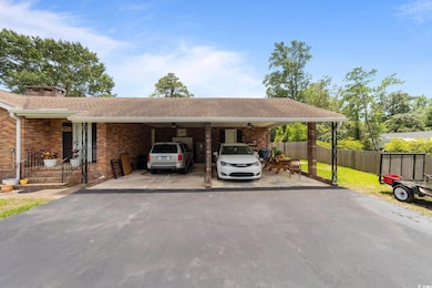 View of vehicle parking with a ceiling fan, driveway, and an attached carport