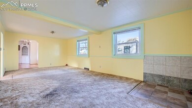 Carpeted spare room with an inviting chandelier