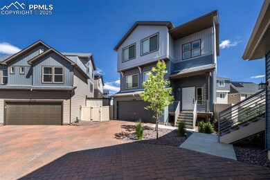 View of front of house featuring a garage, decorative driveway, and board and batten siding