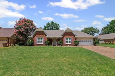 Single story home with roof with shingles, concrete driveway, a front yard, brick siding, and a garage