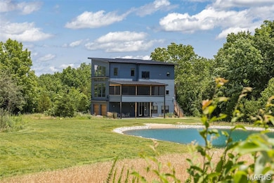 Back of property featuring a sunroom, a lawn, and stairs