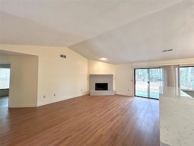 Unfurnished living room with lofted ceiling, a bri
