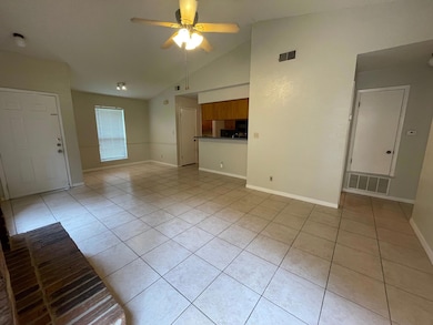 Unfurnished living room featuring light tile patterned floors, a ceiling fan, and high vaulted ceiling