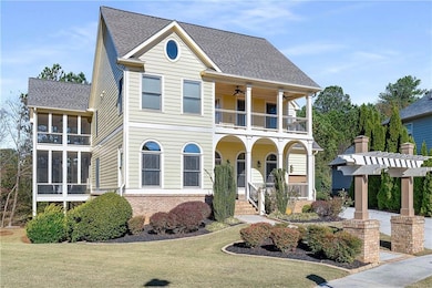 View of front of property with a shingled roof, brick siding, a front yard, and a ceiling fan