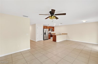 Unfurnished living room featuring a ceiling fan, r
