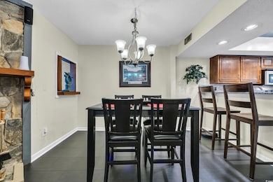 Dining space featuring a chandelier, baseboards, a textured ceiling, recessed lighting, and dark tile patterned floors
