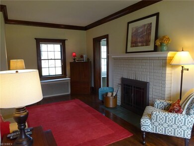Living room has hardwood floors and brick surround