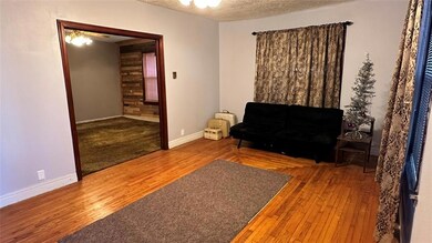 Living area featuring ceiling fan, a textured ceil