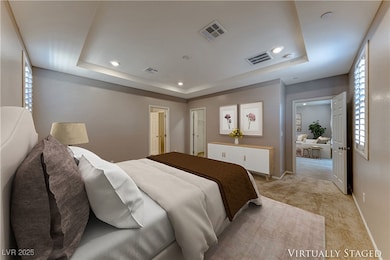 Primary bedroom featuring a raised ceiling, visibl