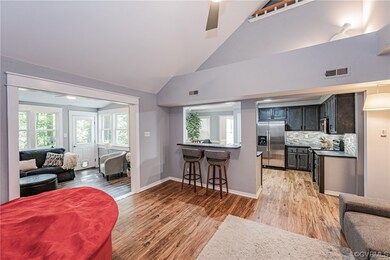 Living room with light hardwood floors, a high cei