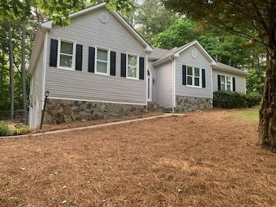 Single story home featuring stone siding