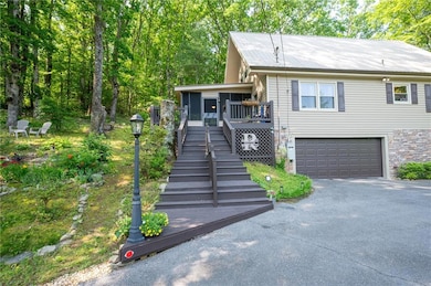 View of front of home featuring driveway, an attached garage, and stairway