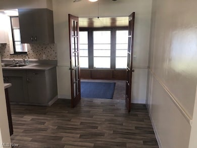 Kitchen with dark hardwood / wood-style floors, ceiling fan, a healthy amount of sunlight, and tasteful backsplash