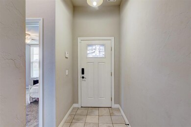 Entryway featuring light colored tile and a wealth
