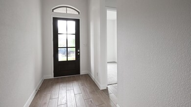 Doorway with wood finished floors, baseboards, an