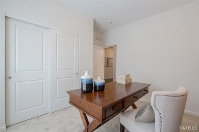 Home office with light colored carpet and baseboards
