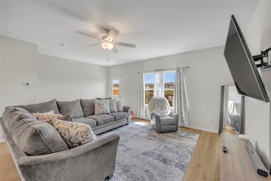 Living room with light wood-style flooring, basebo