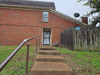 Entrance to property featuring brick siding