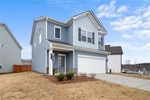 Traditional-style house with a garage, concrete driveway, and board and batten siding