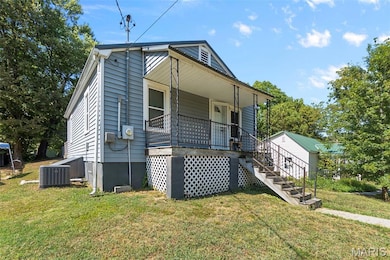 View of front of house featuring a porch, a front yard, and stairs
