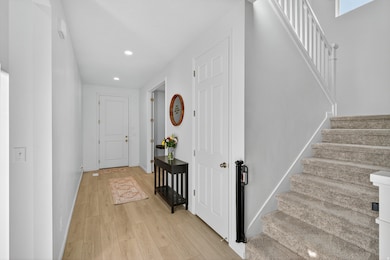 Corridor featuring light wood finished floors, stairs, and recessed lighting