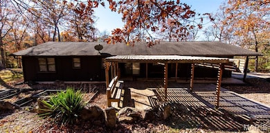 Back of property with a shingled roof, a deck, and board and batten siding