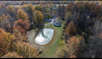 View of property location with a nearby body of water and a forest