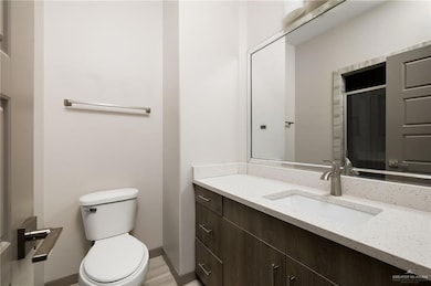 Bathroom with baseboards, vanity, and toilet