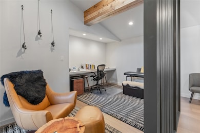 Office area featuring light wood finished floors, built in desk, and recessed lighting