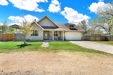 Craftsman house with driveway, fence, and stone s