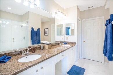 Bathroom featuring walk in shower, vanity, and til