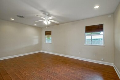 Huge Den with wood flooring, recessed lighting & ceiling fan.