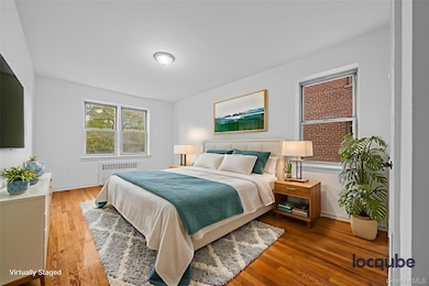 Bedroom with wood finished floors and radiator