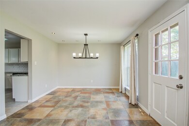 Dining room has a modern chandalier and recessed lighting.