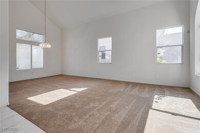 Unfurnished room with light carpet, high vaulted c