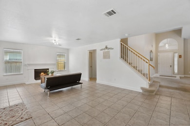 Living room with light tile patterned floors, sta