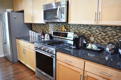 Kitchen with backsplash, light brown cabinetry, a