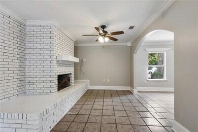 Brick Fireplace seen through archway of Living Roo