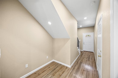 Convenient garage entry opens into the foyer, where a thoughtfully designed nook beneath the stairs adds functional space alongside a stylishly placed guest bathroom — blending practicality with seamless design.