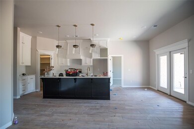 Kitchen featuring a kitchen island with sink, ligh