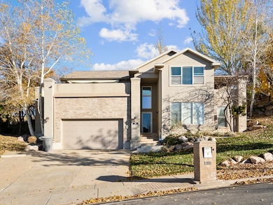 View of front of house featuring concrete driveway, stucco siding, a garage, and brick siding