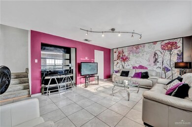 Living area featuring track lighting, tile patterned flooring, stairway, and baseboards