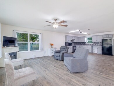 Living room with ceiling fan, plenty of natural li