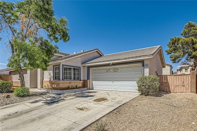 Ranch-style house featuring concrete driveway, fen