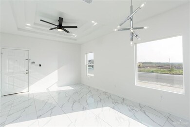 Unfurnished room featuring marble finish floor, a tray ceiling, recessed lighting, and ceiling fan
