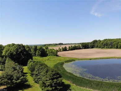 Another view of the lake/pond showing a large fiel