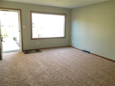 The living room has new carpet, a large picture wi